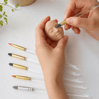 Manos modelando una carita con pinceles de silicona AradiaShop® sobre mesa de trabajo.